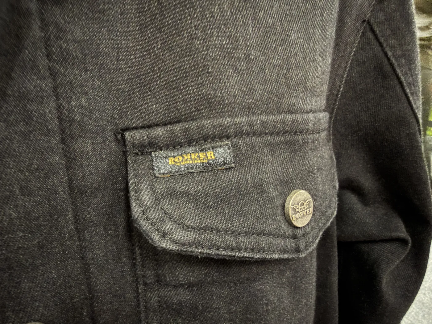 Rokker denimjakke med logo i nærbillede